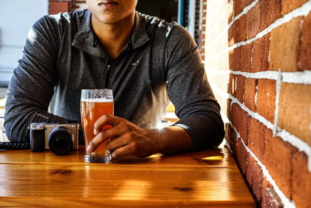 A pint of beer on a wooden bar table
